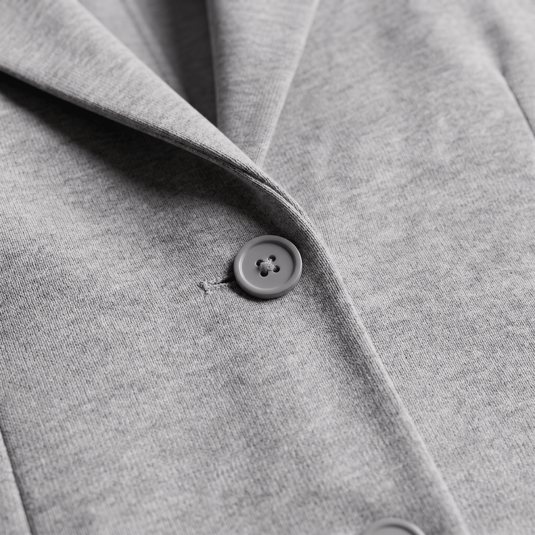 Light gray blazer sleeve with round button and stitched cuff seam