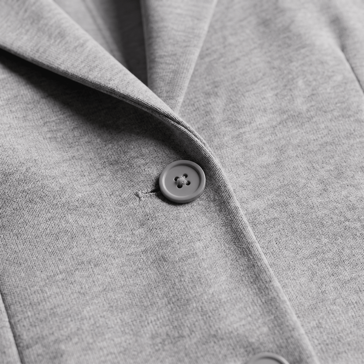 Light gray blazer sleeve with round button and stitched cuff seam