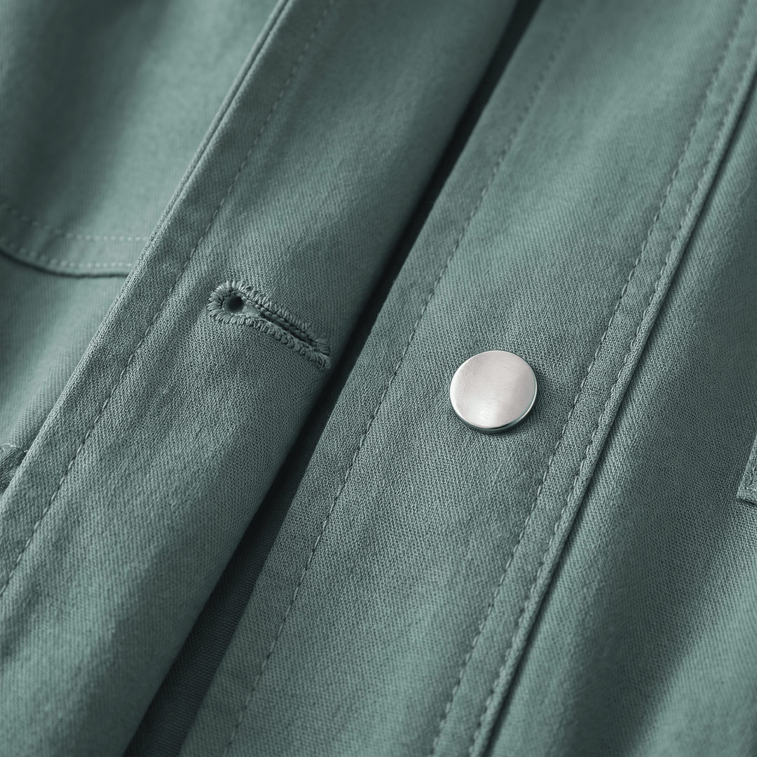 Close-up of green overcoat snap button and stitched flap detailing