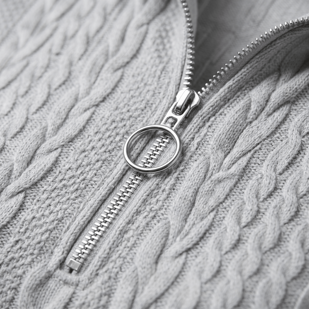 Grey cable-knit sweater close-up of half-zip and textured knit pattern
