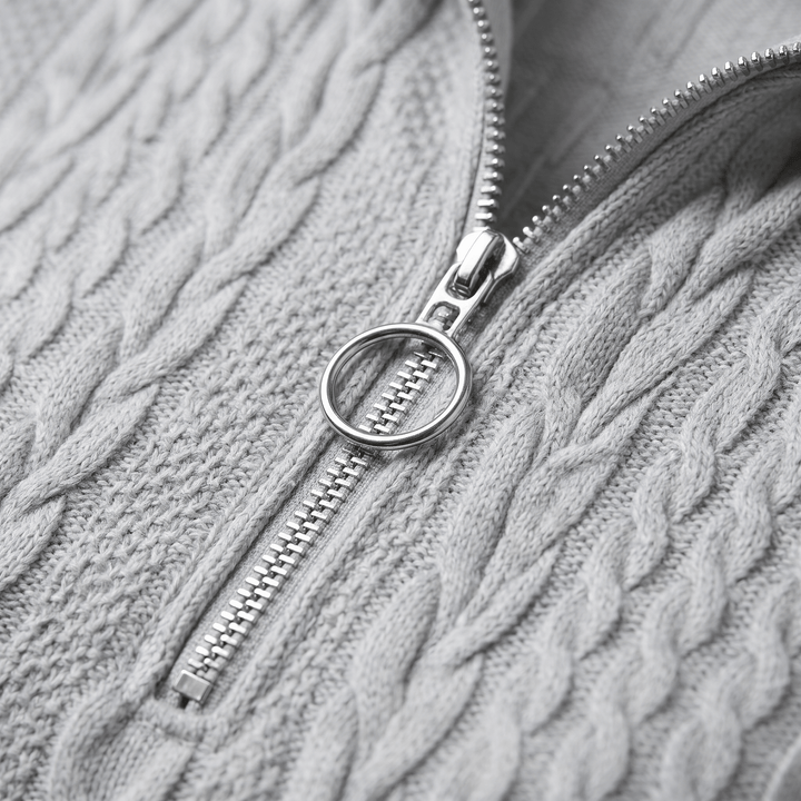 Grey cable-knit sweater close-up of half-zip and textured knit pattern