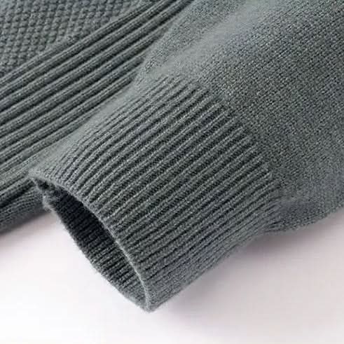 Gray-green jacquard sweater knit close-up, ribbed cuff and textured stitch pattern