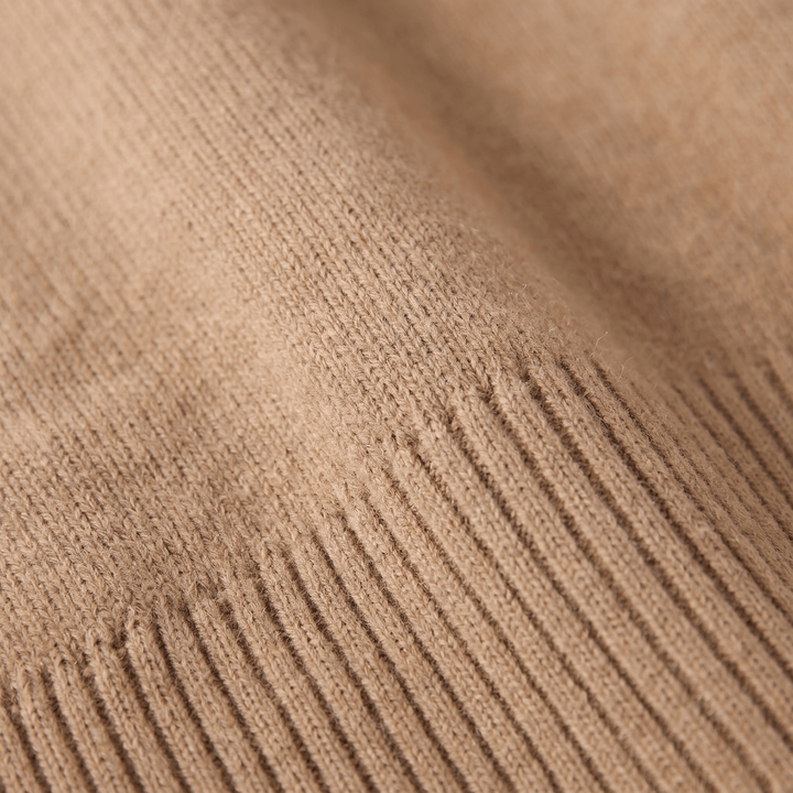 Close-up of camel cashmere turtleneck knit texture with visible ribbing