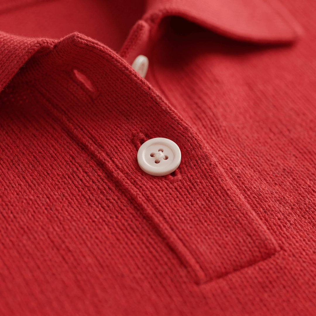 Close-up of red soft knit polo sweater with white button at placket