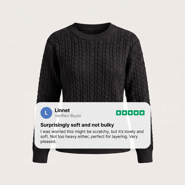 Black cable knit crewneck sweater with long sleeves and ribbed cuffs and hem.