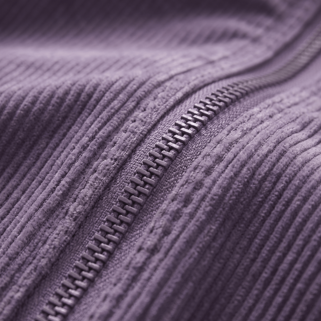 Close-up of purple corduroy jacket zipper and textured fabric