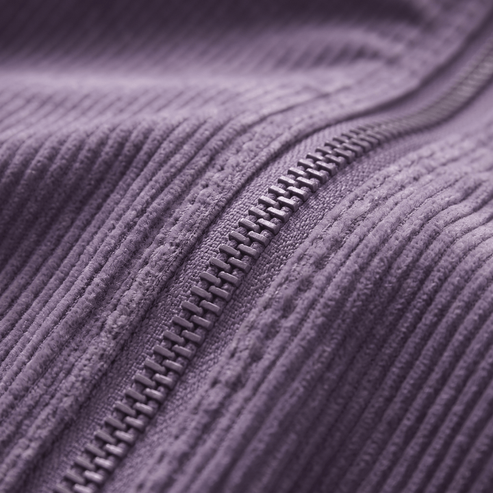 Close-up of purple corduroy jacket zipper and textured fabric