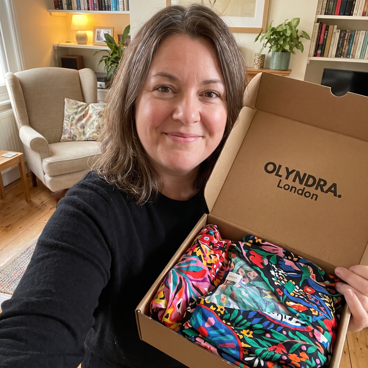 OLYNDRA mystery box with colorful folded clothing inside an open cardboard box
