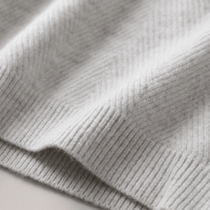Close-up of grey ribbed cuff on textured chevron knit sweater