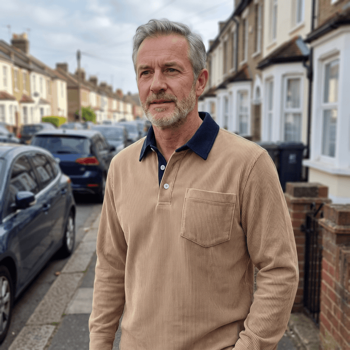 Khaki corduroy polo shirt on a person, long sleeves, navy contrast collar, chest pocket